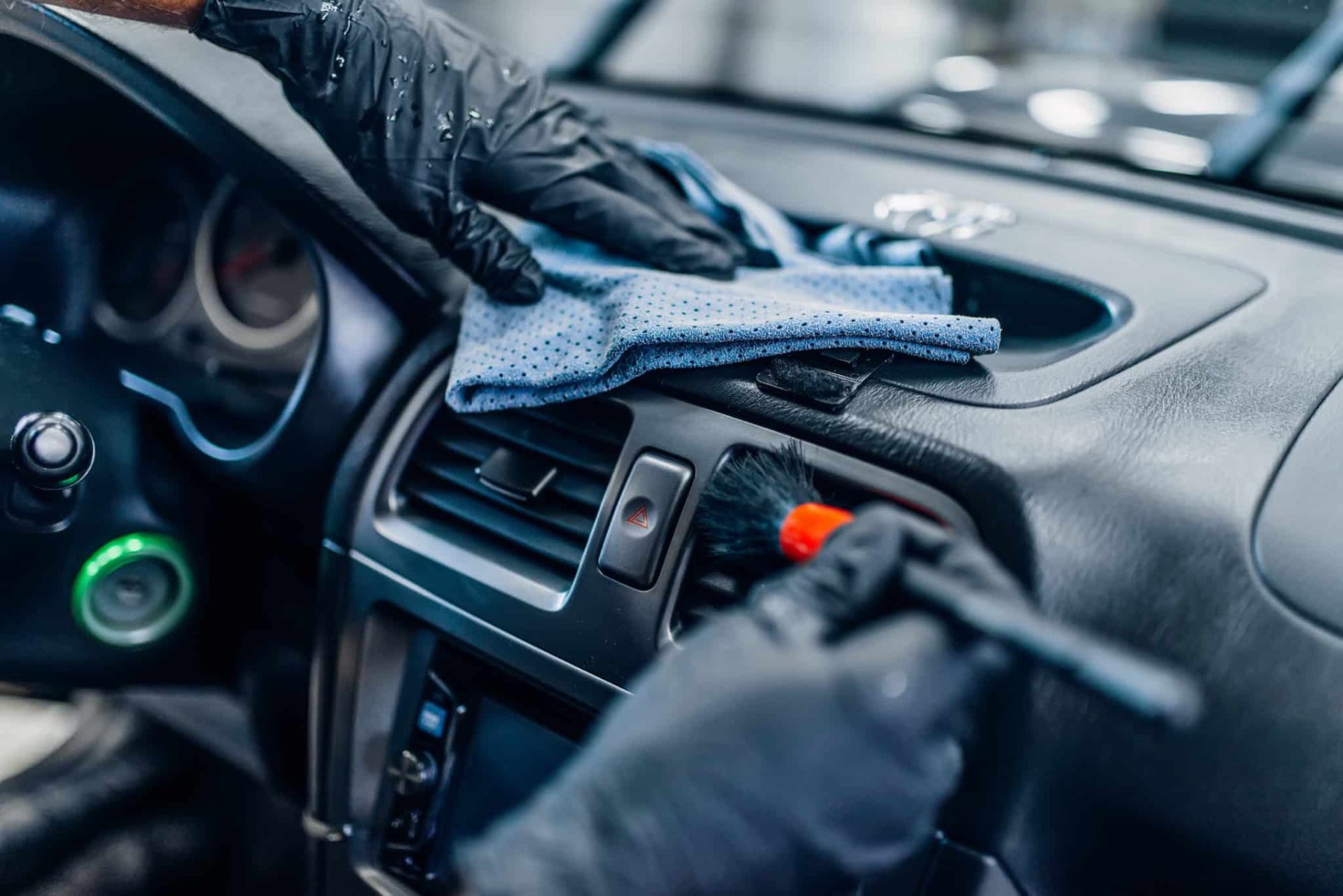 Detailer cleaning vehicle interior dashboard vents